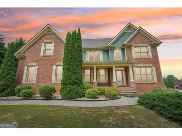 Charming two-story brick home featuring manicured landscaping and a welcoming front porch at 1979 Alcovy Shoals Blf, Lawrenceville, GA 30045