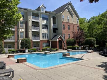 Exterior shot of a building with a community pool, lounge furniture, and landscaped greenery at 3108 Westchester Ne Rdg, Atlanta, GA 30329