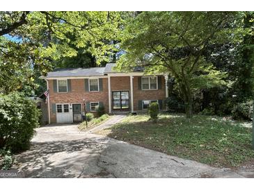 Traditional two-story brick home with green shutters and a mature landscaped front yard at 2425 Wood Valley Dr, Morrow, GA 30260