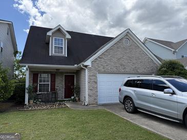 Charming single-Gathering home with brick and siding, features a well-maintained front yard and attached garage at 2075 Tussahaw Xing, Mcdonough, GA 30252