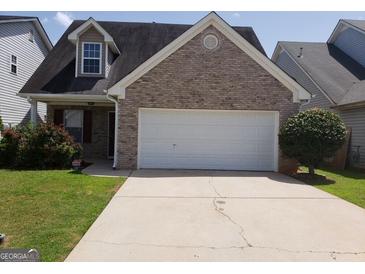 Charming brick-front home with attached garage and well-manicured lawn, creating a welcoming curb appeal at 2075 Tussahaw Xing, Mcdonough, GA 30252