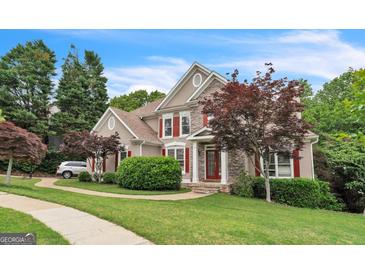 Charming two-story home boasts a stone and stucco facade, complemented by manicured landscaping and a lush green lawn at 2693 Blairsden Nw Pl, Kennesaw, GA 30144