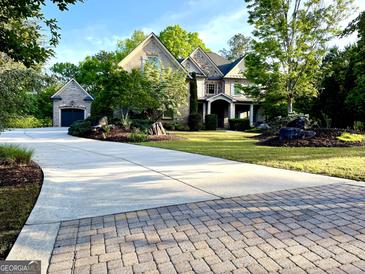 Beautiful two-story brick home with attached garage, large driveway, and manicured landscaping at 1345 Cashiers Way, Roswell, GA 30075