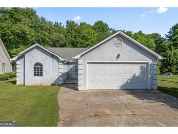 Charming single-story home featuring a two-car garage and well-maintained lawn at 135 Gingercake Ct, Fayetteville, GA 30214