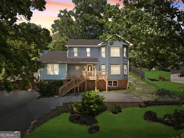 Charming two-story home with a wooden porch and a well-maintained front yard at 6942 Cottonwood Trl, Riverdale, GA 30296