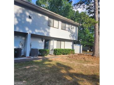 Two-story townhouse featuring a well-maintained front yard with a trimmed hedge and mature trees at 3818 Mulkey Sw Cir, Marietta, GA 30008