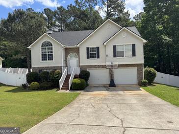 Charming two-story home with attached two-car garage, landscaped yard, and traditional architectural details at 85 Creekside Trl, Covington, GA 30016