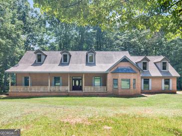 Charming brick home featuring a welcoming front porch and lush greenery, perfect for relaxation and curb appeal at 95 Fern Ct, Stockbridge, GA 30281