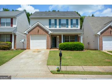 Charming two-story home features a brick facade, attached garage, and a well-maintained front lawn at 4511 Ravenwood Pl # 70, Union City, GA 30291