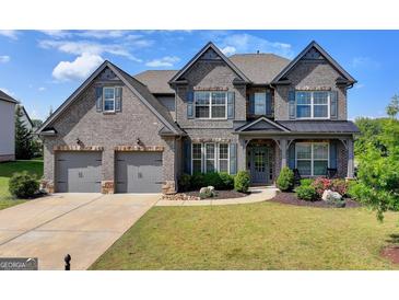Stunning two-story brick home with a three-car garage and well-manicured lawn at 7575 Old Camp Lndg, Cumming, GA 30040