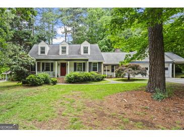 Charming home with a well-manicured lawn, inviting front porch, and mature trees at 1680 Huntington Dr, Marietta, GA 30066
