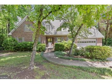 Charming brick home with manicured landscaping and inviting walkway to the entrance at 886 Pine Needle Rd, Hampton, GA 30228
