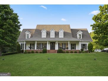 Beautiful exterior showcasing a charming two-story home with well-manicured lawn and inviting front porch at 885 Kelleytown Rd, Mcdonough, GA 30252
