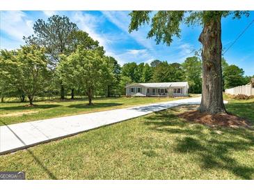 Charming single-story home featuring a sprawling front yard and inviting driveway at 203 Brannan Rd, Mcdonough, GA 30253