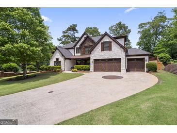 Beautiful stone-accented home featuring a manicured lawn and a spacious driveway leading to a two-car garage at 2265 Venture Dr, Marietta, GA 30062