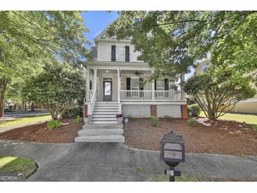 Charming two-story home with a welcoming front porch, landscaped yard, and black shutters at 100 Concord Ct, Fayetteville, GA 30214
