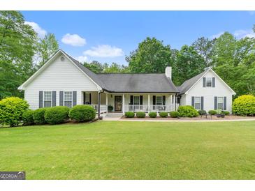 Charming home with a covered front porch and meticulously manicured lawn at 480 Holly Hills Ln, Mcdonough, GA 30252