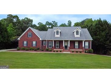 Charming red brick home boasts a lush lawn and mature landscaping at 1118 Sequoia Trl, Mcdonough, GA 30252