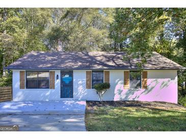 Charming, remodeled single-story home boasts a brick facade, mature trees, and a well-manicured lawn at 2066 Tidwell Trl, Stone Mountain, GA 30088