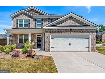 Beautiful two-story brick home featuring an attached two-car garage and professionally landscaped front yard at 600 Dairy Dr, Stockbridge, GA 30281