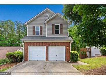 Charming two-story home with a brick and vinyl exterior, two-car garage, and well-maintained landscaping at 164 Stoneforest Dr, Woodstock, GA 30189