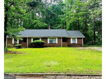 Charming single-story brick home with a well-maintained front yard and a backdrop of lush trees at 105 Meadowbrook Ct, Fayetteville, GA 30215