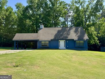 Charming blue home with a well-manicured lawn and a convenient covered carport at 105 Harris Ct, Stockbridge, GA 30281