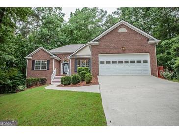Charming brick home with a manicured lawn, attached garage, and beautifully landscaped front yard at 2074 Ayers Creek Ct, Villa Rica, GA 30180