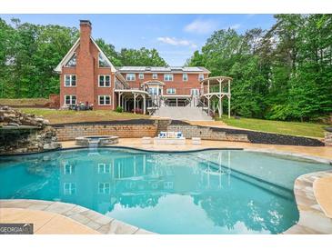 Stunning pool area with stone waterfall, spa, and luxurious backyard in a beautiful brick home setting at 1212 Lee Whatley Dr, Lithonia, GA 30058