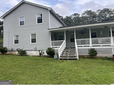 Charming two-story home with gray siding, a welcoming porch, and a well-maintained lawn at 1125 Babbs Mill Rd, Hampton, GA 30228