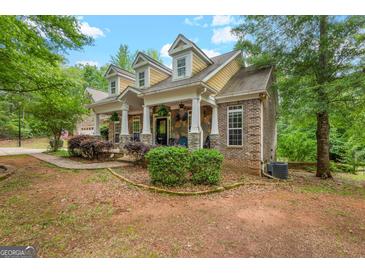 Charming home exterior featuring brick, stone accents, dormer windows and a welcoming front porch at 2294 Hollonville Rd, Brooks, GA 30205