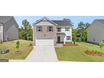 Charming two-story home with a brick and siding exterior, two-car garage, and well-manicured front yard at 178 Aster, Locust Grove, GA 30248