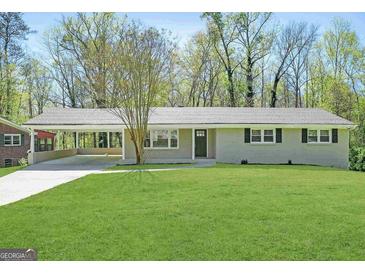 Charming single-story home featuring a spacious front lawn and a convenient covered carport at 1889 Silver Creek Dr, Austell, GA 30168