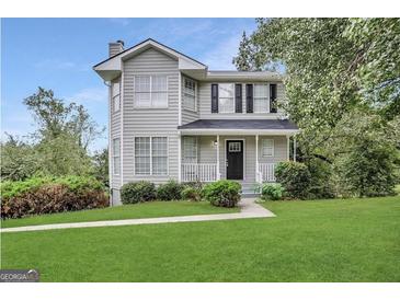 Charming two-story home with a well-manicured front lawn and lush landscaping at 4467 Thornwood Cres, Stone Mountain, GA 30083