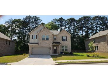 Charming two-story brick home with a two-car garage and well-maintained lawn at 116 Cabin Way, Hampton, GA 30228