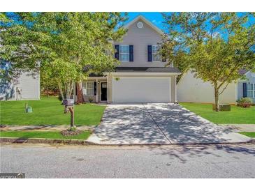 Charming two-story home featuring a well-maintained lawn and a two-car garage at 9151 Jefferson Village Sw Dr, Covington, GA 30014