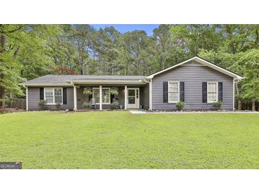Charming single-story home with a well-manicured lawn, covered porch, and gray siding at 125 Wendell Ct, Fayetteville, GA 30215