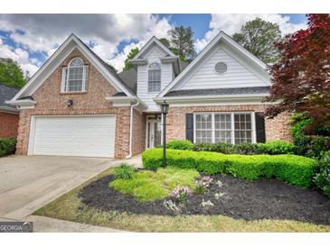 Charming brick home with manicured landscaping and a two-car garage at 1880 Hickory Station Cir, Snellville, GA 30078