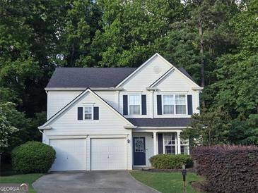 Charming two-story home with a well-manicured lawn and a two-car garage nestled among lush trees at 2022 Maple Ridge, Acworth, GA 30101