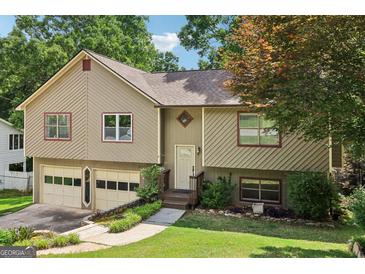 Charming home featuring a two-car garage, complemented by a beautifully landscaped front yard at 2958 Cordite Loop, Snellville, GA 30039