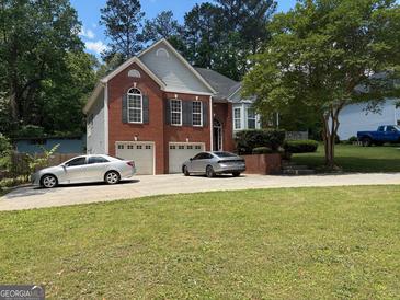 Charming two-story brick home featuring an attached two car garage and a well manicured front yard at 2828 Hicks Sw Rd, Marietta, GA 30060