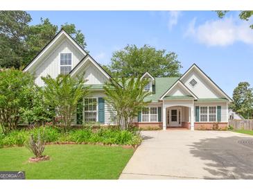 Charming home with a lush green lawn, mature trees, and a long driveway at 2340 Landrum Ct, Lawrenceville, GA 30043