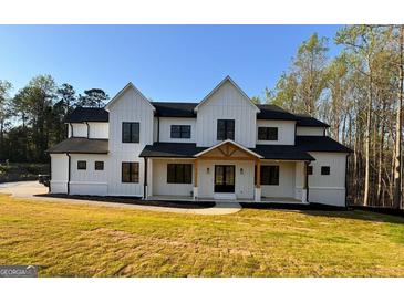 Stunning two-story modern farmhouse with black trim and a welcoming covered porch at 3180 Lee Dr, Buford, GA 30518