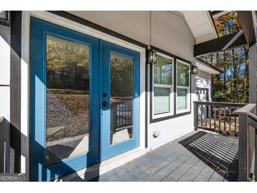 Inviting porch with blue double doors and black trim creating a modern and stylish entryway at 7428 Mockingbird Trl, Riverdale, GA 30274