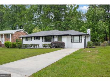 Charming white brick home with a well-maintained lawn, mature trees, and a paved driveway at 2315 Shancey Ln, South Fulton, GA 30349