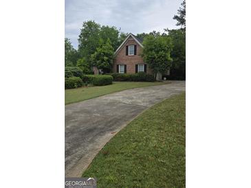Charming brick home with a well-manicured lawn and a curved driveway at 2329 Lochinver Sw Ln, Conyers, GA 30094