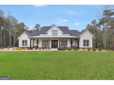 Inviting two-story modern farmhouse with black accents, a front porch, and a lush green lawn at 3911 Peeksville Rd, Locust Grove, GA 30248