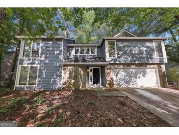 Charming two-story home with a stone accent, attached garage and professionally landscaped front yard at 5362 Kelleys Mill Cir, Stone Mountain, GA 30088