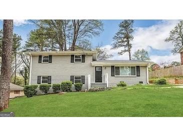 Charming two-story home with painted brick, black shutters, green lawn, and mature trees at 4049 Brookcrest Cir, Decatur, GA 30032