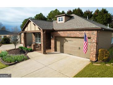 Charming single-story brick home featuring an attached two-car garage and an inviting covered front porch at 511 Bonneset Ct, Canton, GA 30114